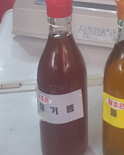 방학동 참조은농산물에서 직접 짠 참기름 병. 붉은 뚜껑에 맑은 갈색 기름이 담겨 있다.