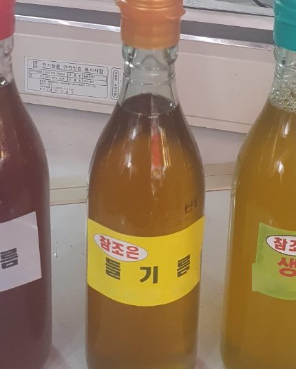 방학동 참조은농산물에서 직접 짠 들기름 병. 주황 뚜껑에 맑은 황금빛 기름이 담겨 있다.