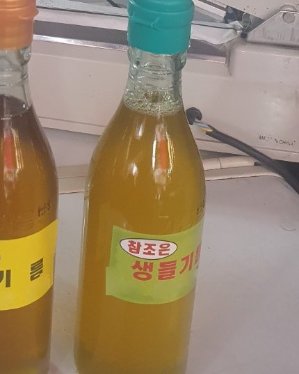 방학동 참조은농산물에서 덜 볶아 짠 생들기름 병. 청록 뚜껑에 연한 노란빛 기름이 담겨 있다.
